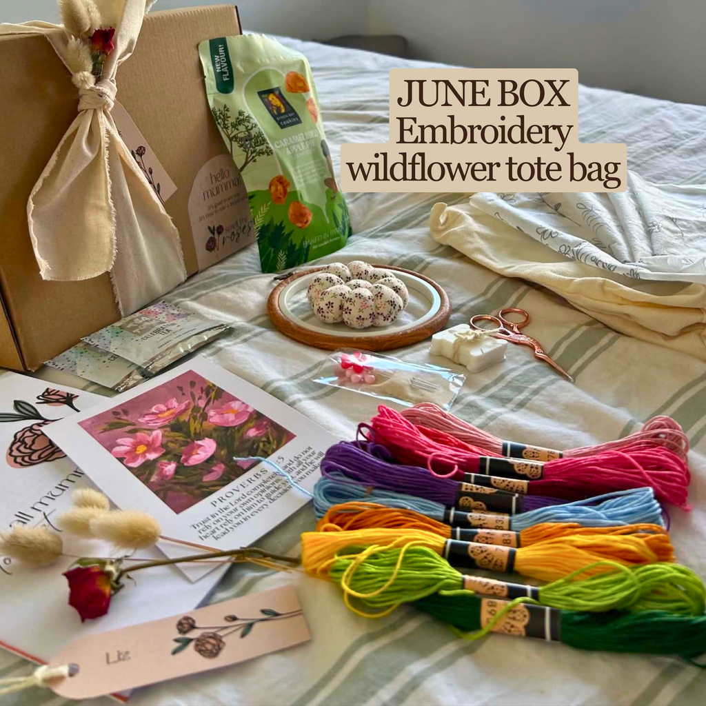 Embroidery kit with wildflower tote bag materials on a bed